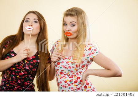 Two happy women holding fake lips on stick Two happy women holding fake lips on stick 121501408