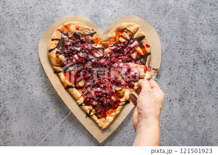 Food for Valentine's Day. Heart shaped sweet pizza with pineapple on gray background. View from above. Romantic dinner. 121501923