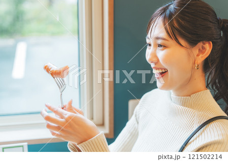 クラフトビールのおつまみにソーセージを食べる女性二人 121502214