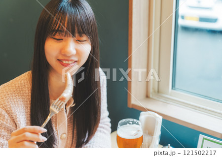 クラフトビールのおつまみにソーセージを食べる女性二人 クラフトビールのおつまみにソーセージを食べる女性二人 121502217