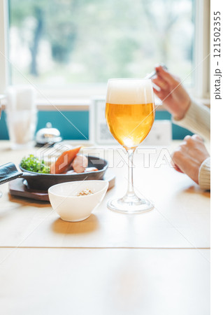 ビールで乾杯する若い女性二人 ビールで乾杯する若い女性二人 121502355