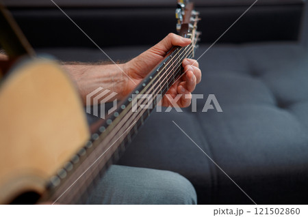 Guitarist on acoustic guitar playing melody. Close up musician instrument with pick in hand 121502860