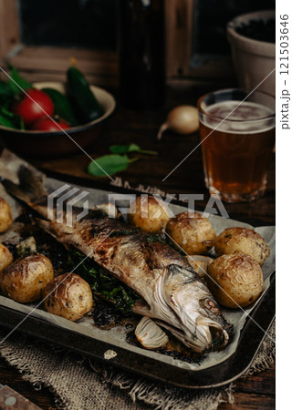 Sea Bass Baked with New Potatoes and Onion 121503646