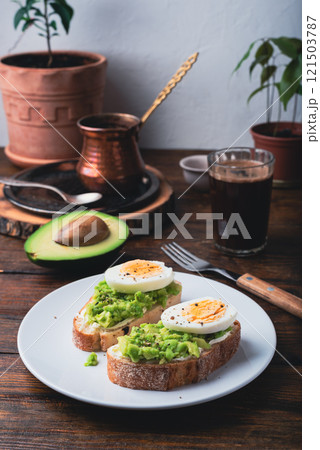Toasts with mashed avocado, cream cheese and boiled egg Toasts with mashed avocado, cream cheese and boiled egg 121503787