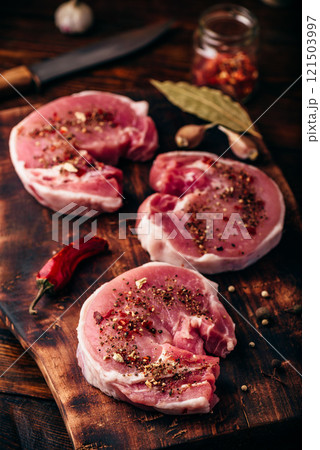 Raw pork loin steaks with different spices 121503997