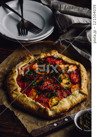 Baked tomato galette on baking paper 121504039