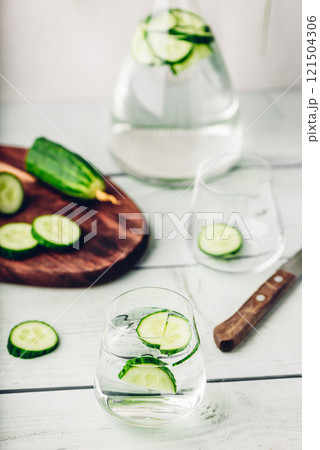 Water infused with sliced cucumber Water infused with sliced cucumber 121504306