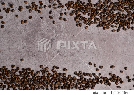 Top view above and below roasted coffee beans on gray concrete. Copy space background, cover, backdrop, texture. Place for adding text or design Top view above and below roasted coffee beans on gray concrete. Copy space background, cover, backdrop, texture. Place for adding text or design 121504663