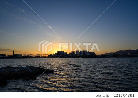 屋市のマンションがシルエットに沈む海辺の光景。西宮市香櫨園浜で撮影 121504891