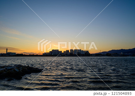 屋市のマンションがシルエットに沈む海辺の光景。西宮市香櫨園浜で撮影 屋市のマンションがシルエットに沈む海辺の光景。西宮市香櫨園浜で撮影 121504893