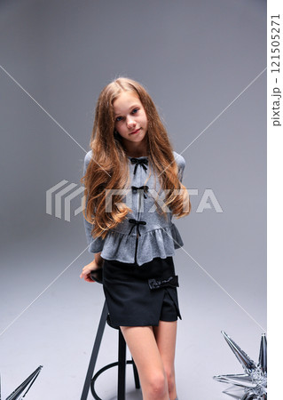A Stylish Young Girl Strikes a Pose in a Trendy and Modern Fashion Photoshoot Setting 121505271