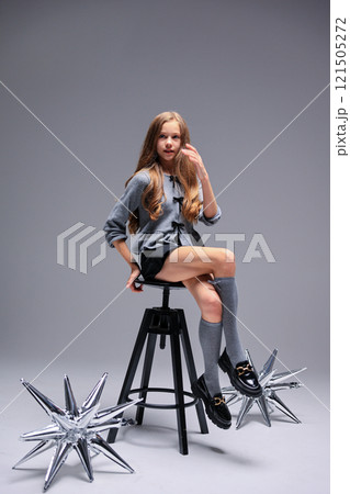 A Sleek and Stylish Fashion Shoot Featuring a Young Model Surrounded by Decorative Elements 121505272