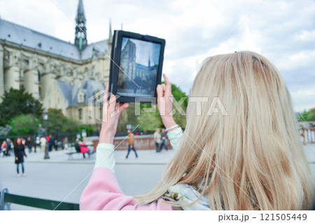Blonde woman tourist in Paris making selfie with Notre-Dame 121505449