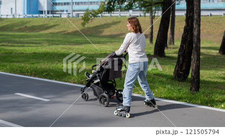 Caucasian woman roller skating with her toddler son in a stroller. Caucasian woman roller skating with her toddler son in a stroller. 121505794