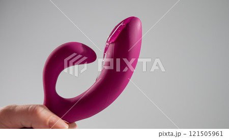 Lube pouring on pink dildo on white background.  121505961
