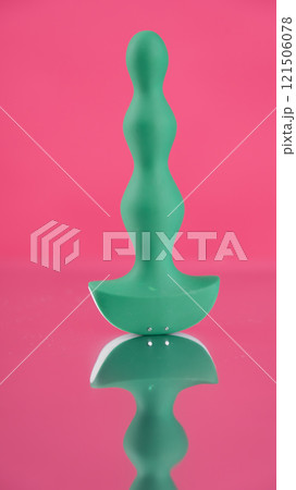 Green anal beads on pink mirror background.  Green anal beads on pink mirror background.  121506078