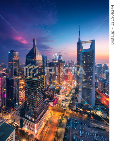 A bustling cityscape at twilight, with towering skyscrapers and illuminated streets 121506244