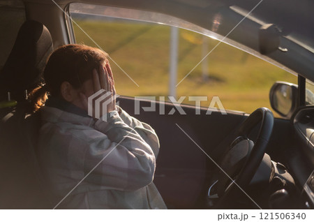Caucasian woman cries while driving.  121506340
