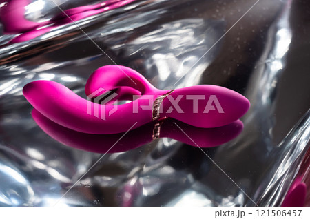 Sex toy on a metal background in the reflections of light.  121506457