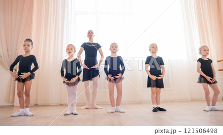 Children's ballet school. Caucasian woman teaching ballet to little girls. Children's ballet school. Caucasian woman teaching ballet to little girls. 121506498