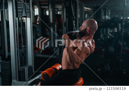 Caucasian man doing lat pull-downs on a machine.  121506519