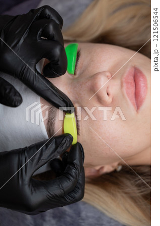 Caucasian woman undergoing eyelash lamination procedure. Caucasian woman undergoing eyelash lamination procedure. 121506544