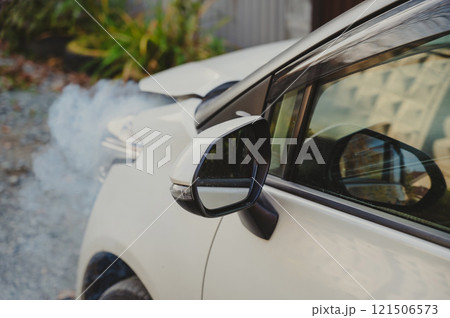 Smoke is coming from under the hood of the car. Smoke is coming from under the hood of the car. 121506573