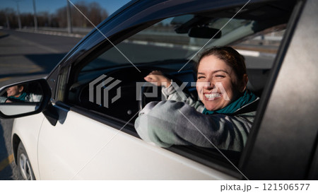 Happy Caucasian woman sitting behind the wheel looking out the window and smiling. Happy Caucasian woman sitting behind the wheel looking out the window and smiling. 121506577