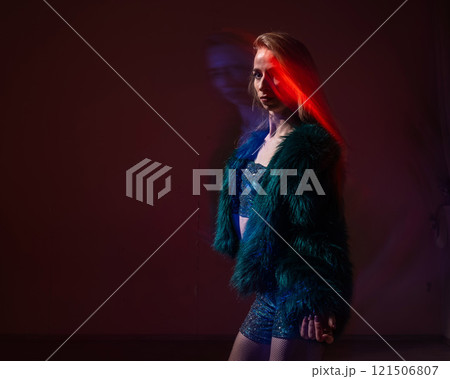 A young woman dances contemporary dances in blue and red light. Long exposure photo. A young woman dances contemporary dances in blue and red light. Long exposure photo. 121506807