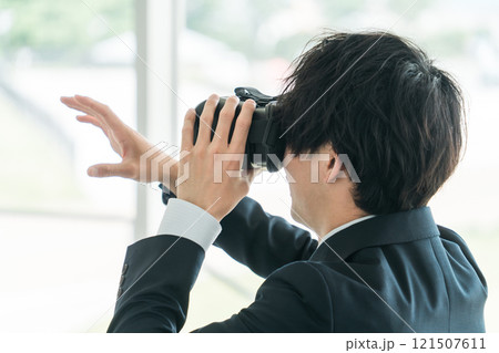 VRゴーグルをつけてバーチャルリアリティ・メタバースを体験するビジネスマン・研修 121507611