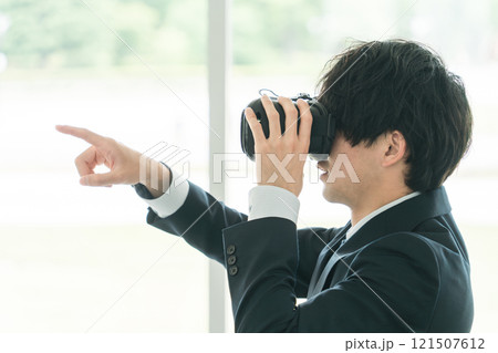 VRゴーグルをつけてバーチャルリアリティ・メタバースを体験するビジネスマン・研修 121507612