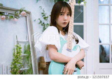 エレキギターを持つロングヘアの若い女性 121507837