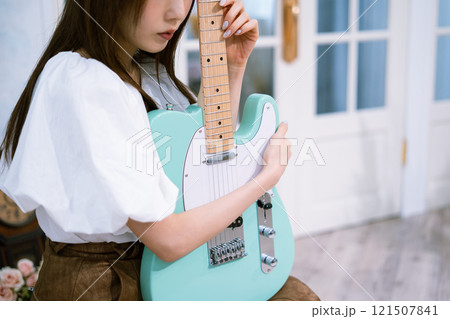 エレキギターを持つロングヘアの若い女性 121507841