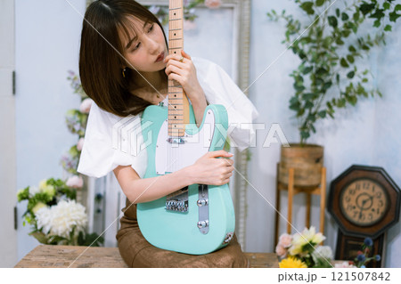 エレキギターを持つロングヘアの若い女性 121507842