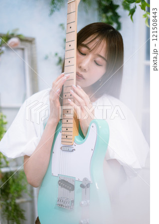 エレキギターを持つロングヘアの若い女性 121508443