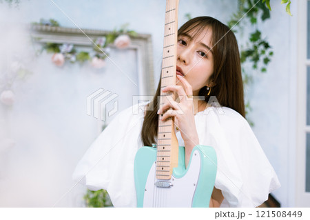 エレキギターを持つロングヘアの若い女性 121508449