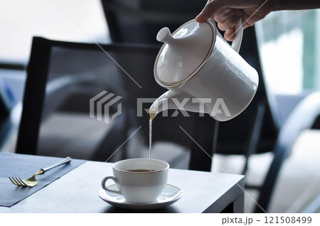 pouring tea , tea cup and tea pot or hot tea 121508499