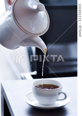 pouring tea , tea cup and tea pot or hot tea pouring tea , tea cup and tea pot or hot tea 121508503