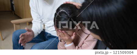 悩んで悲しむ泣く子どもと慰める両親　イジメや悩みのイメージ 121509304