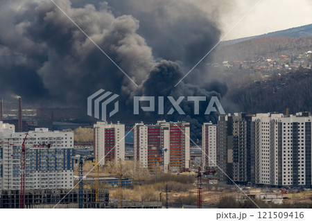 Black smoke from a fire in the city. 121509416