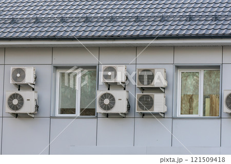 Air conditioner coolers on the wall of the house around the windows. Air conditioner coolers on the wall of the house around the windows. 121509418