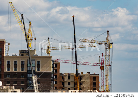 Building under construction with cranes against the background of a cloudy sky. Building under construction with cranes against the background of a cloudy sky. 121509419