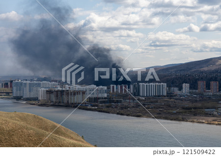 Black smoke from a fire in a city on the other side of the river. Black smoke from a fire in a city on the other side of the river. 121509422