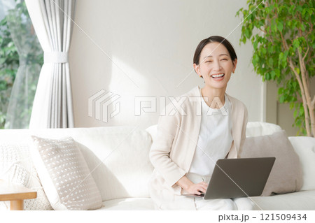 ソファでパソコン作業をする女性 121509434