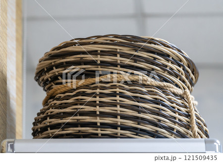 Wicker basket made of brown and yellow rods. 121509435