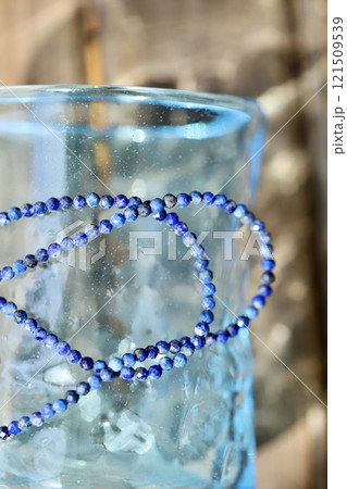 琉球グラスの上に置いたラピスラズリのビーズネックレス 121509539