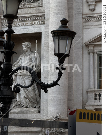 A street lamp illuminates the scene next to a detailed statue depicting a historical figure in Rome. The contrast of old architecture with contemporary elements creates a unique atmosphere. A street lamp illuminates the scene next to a detailed statue depicting a historical figure in Rome. The contrast of old architecture with contemporary elements creates a unique atmosphere. 121510311