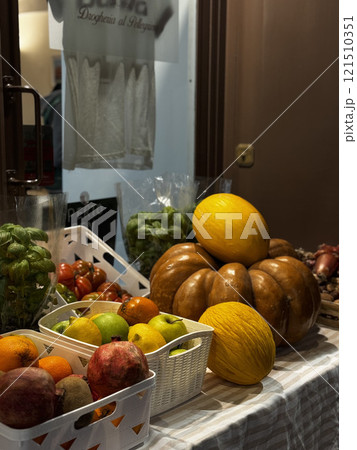 A variety of fresh fruits and vegetables are arranged neatly at a market stall during the evening. The scene captures the vibrancy of local produce and the inviting atmosphere. A variety of fresh fruits and vegetables are arranged neatly at a market stall during the evening. The scene captures the vibrancy of local produce and the inviting atmosphere. 121510351