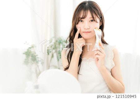 美顔器でマッサージしながらお肌に悩む若いアジア人女性(スキンケア) 美顔器でマッサージしながらお肌に悩む若いアジア人女性(スキンケア) 121510945