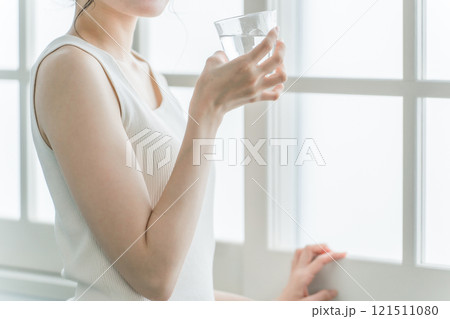 家で水・ミネラルウォーター・白湯をコップで飲むリラックスした女性 121511080